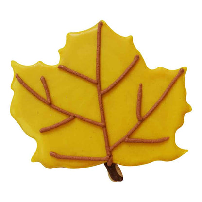 Decorated yellow maple leaf cookie with detailed veins, made using a maple leaf cookie cutter.