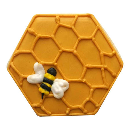 Decorated hexagon cookie with a honeycomb pattern and a bee detail, made using the hexagon cookie cutter.