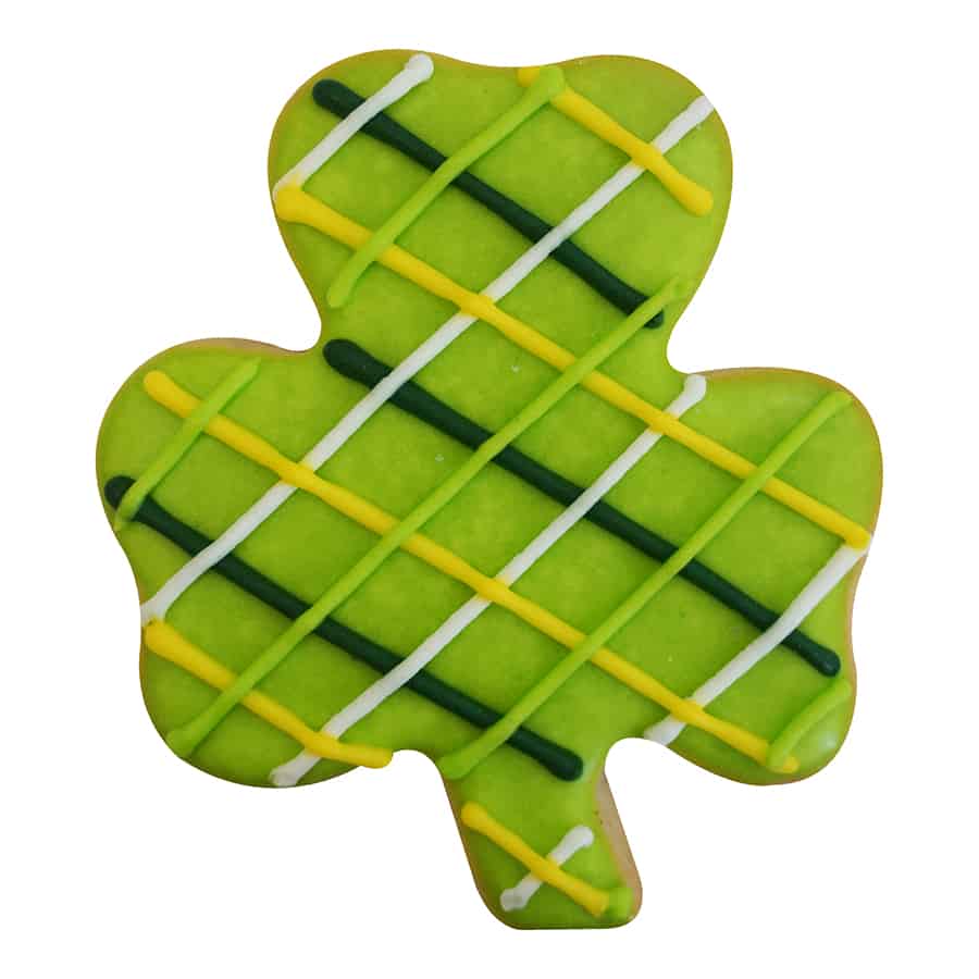 Decorated shamrock-shaped cookie with green icing and colorful crisscross patterns.