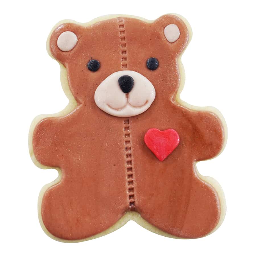 Decorated teddy bear cookie featuring a stitched design, a red heart accent, and adorable facial details.