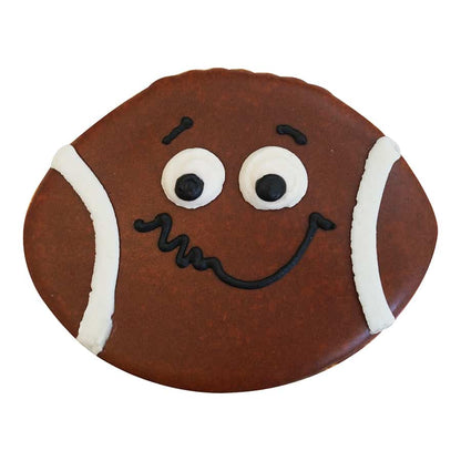 Decorated football-shaped cookie with a playful smiling face design, featuring white stripes and black accents for a whimsical look.