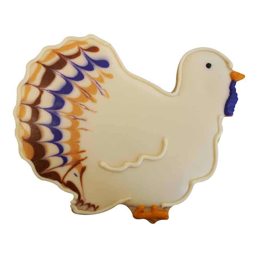 Whimsical white turkey-shaped cookie with intricately piped feathers in fall colors.