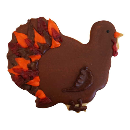 Decorated turkey-shaped cookie with brown icing and colorful feather details.