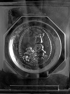 Clear plastic chocolate mold showing an octagonal plate design with a raised Easter scene in the center medallion, surrounded by a circular frame.
