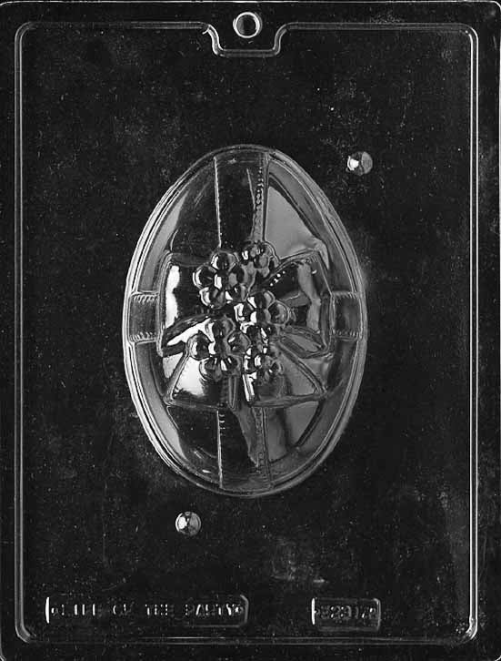 Clear plastic chocolate mold showing the top half of an egg with a raised ribbon band, bow, and clustered flowers in relief for an ornate 3D chocolate egg.