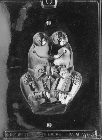 Clear plastic mold showing the front half of a large frog: rounded eyes, smiling face, front legs folded with floral accents near the wrists; deep cavity sized about 4.5 x 5.875 inches for casting the front of a 3D chocolate frog.