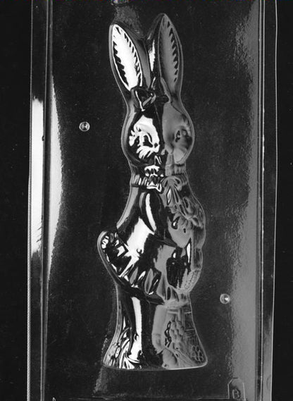 Clear plastic chocolate mold showing the front half of a tall girl bunny with upright ears, a bow at the neck, and dress-style detailing on the body.