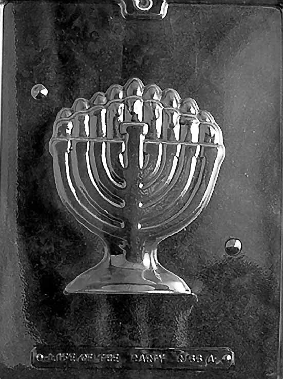Clear plastic chocolate mold showing one half of a detailed menorah with curved arms, candle shapes across the top, and a pedestal base for a 3D Hanukkah chocolate.