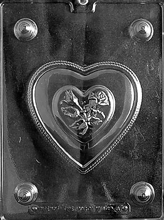 Clear plastic mold showing a heart-shaped chocolate lid with raised rose and double-heart design, surrounded by a beaded edge detail.