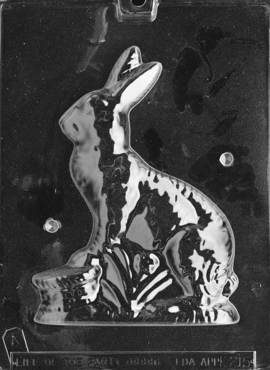 Clear plastic chocolate mold showing the front half of a sitting bunny with upright ears beside a small basket, with textured fur and base details.
