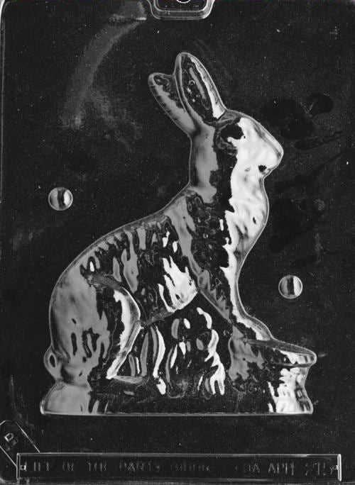 Clear plastic chocolate mold showing the back half of a seated bunny and basket design, created to pair with the front half for a complete 3D chocolate figure.
