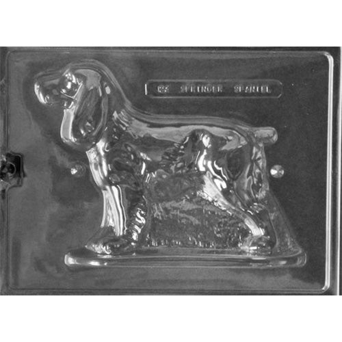 Clear plastic chocolate mold half shaped like a standing Springer Spaniel with floppy ears and textured fur detail, shown on a dark background.