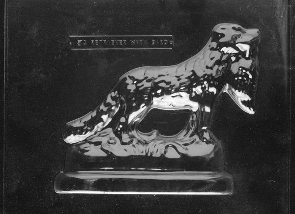 Clear plastic chocolate mold showing the front half of a Golden Retriever in a working pose holding a bird, with textured fur and defined legs.