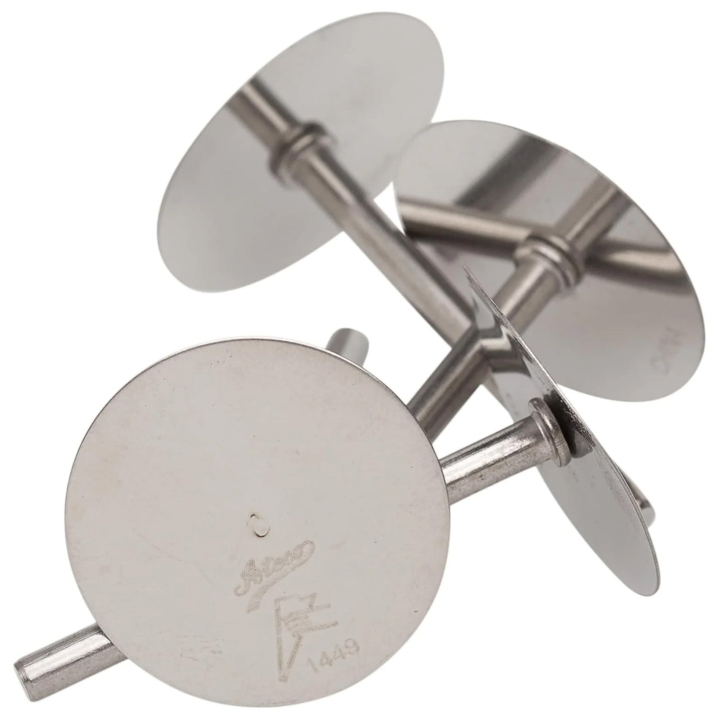 Four stainless steel cake heating cores with round flat tops and short cylinder stems, stacked together on a white background, used to help cakes bake evenly.