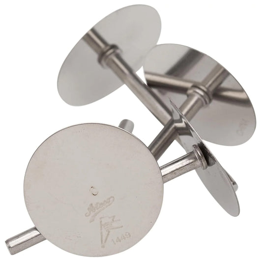 Four stainless steel cake heating cores with round flat tops and short cylinder stems, stacked together on a white background, used to help cakes bake evenly.