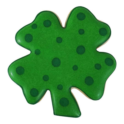 Decorated four-leaf clover cookie with green icing and polka dot details.