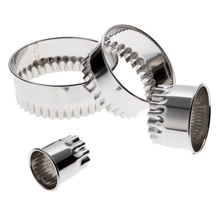 Four stainless steel round fluted cookie cutters separated to show different diameters, each with a scalloped cutting edge on a white background.