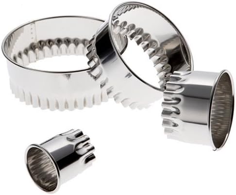 Scattered view of Ateco 4-piece stainless steel fluted round cutter set, designed for precise cutting of cookies, fondant, and pastries with a decorative edge.