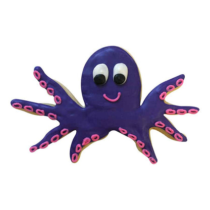 Decorated purple octopus cookie with pink suction cups and a smiling face.