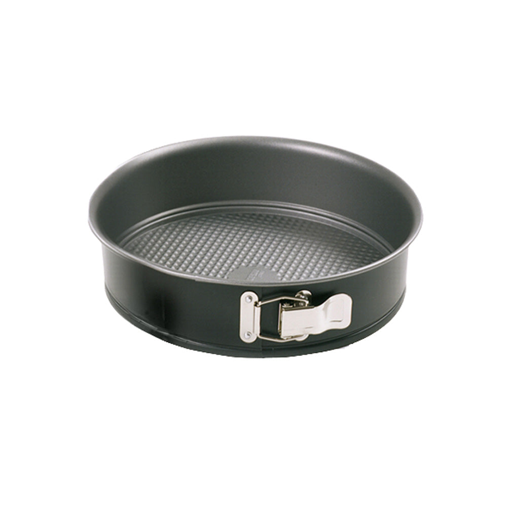 Empty round 7-inch black nonstick springform pan with a textured base and shiny silver latch, photographed against a white background.