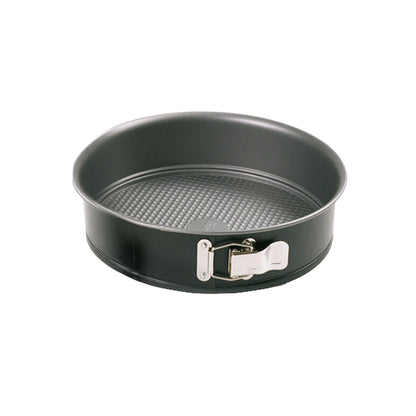 Empty round 7-inch black nonstick springform pan with a textured base and shiny silver latch, photographed against a white background.
