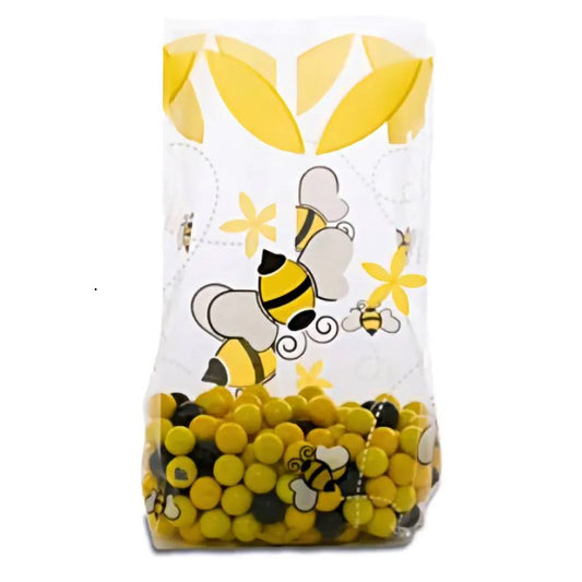 Clear gusseted cello treat bag with yellow and black bee illustrations and small yellow flowers, filled with yellow and black candy pieces, on a white background.