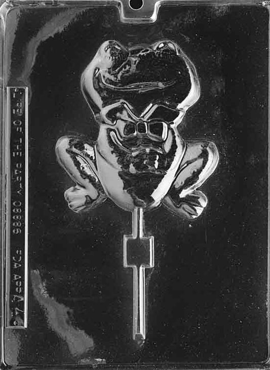 Plastic mold with large frog-shaped lollipop cavities showing eyes, limbs, and rounded belly.