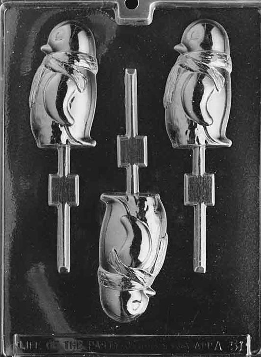 Clear mold with lollipop cavities shaped like penguins wearing scarves; rounded bellies and face details visible.