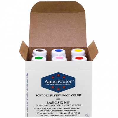 AmeriColor Soft Gel Paste Basic Six Kit with box open, revealing six gel food coloring bottles labeled with color-coded caps for easy identification.