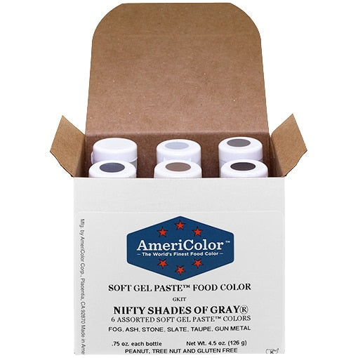 Open box of AmeriColor Soft Gel Paste Nifty Shades of Gray Kit showing six color-coded bottles in a neatly arranged layout with labeled caps.