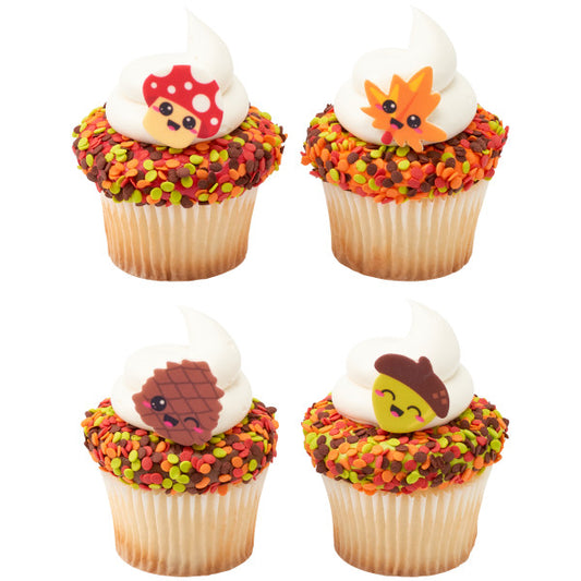 Cupcakes topped with whipped frosting and decorated with Autumn Thanksgiving sequins and cartoon fall-themed toppers.