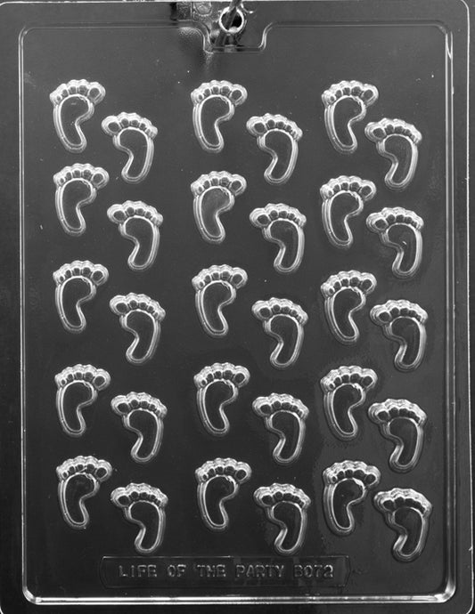 Clear mold sheet with multiple tiny footprint cavities; shallow depth and crisp toe detail; white background.