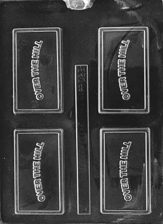 Clear chocolate mold labeled “OVER THE HILL”; rectangular plaque with raised text; dimensions as noted.