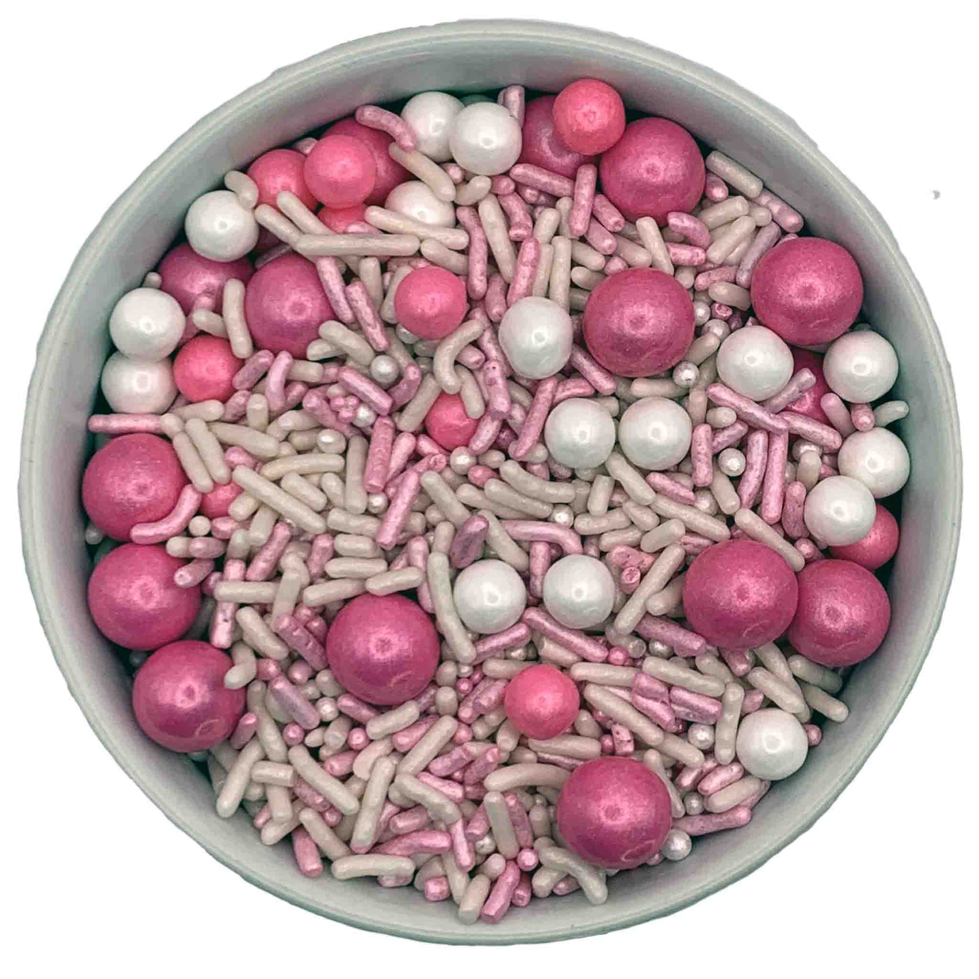 A bowl of pink and white sprinkles featuring smaller sugar pearls, pink sixlets, and a mix of pink and white jimmies, perfect for decorating baby shower or gender reveal desserts.