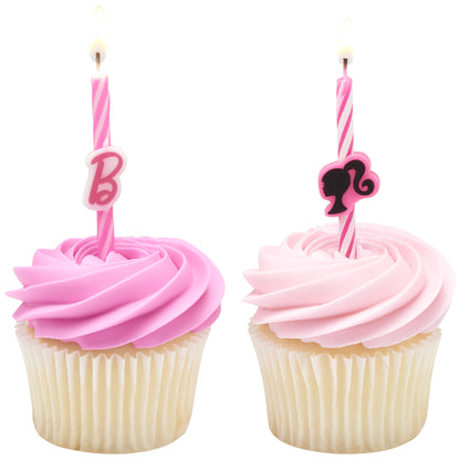 Two lit Barbie birthday candles displayed on pink frosted cupcakes, one with a pink “B” accent and one with a black Barbie silhouette design.