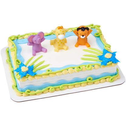 A rectangular cake decorated with blue and green icing, featuring the tiger, giraffe, and elephant figurines as toppers.