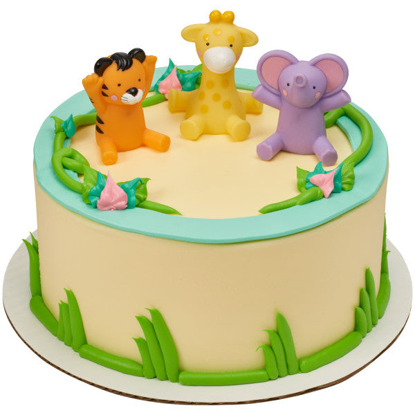 A round cake with jungle-themed decorations, topped with the tiger, giraffe, and elephant figurines.