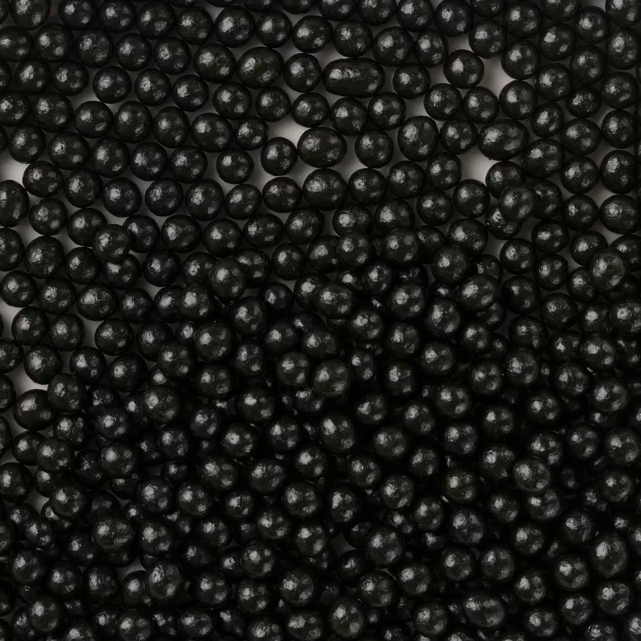Edible pearlized dragees in gloss black, 4mm. Sleek candy pearls for cakes, cupcakes, cookies, and sprinkle mixes. Elegant accents for modern bakes.