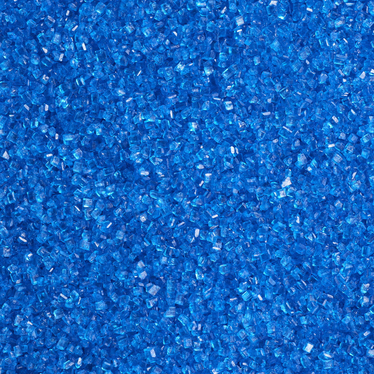 Close-up of bright blue sanding sugar showing coarse, translucent blue sugar crystals with sparkling, faceted surfaces and vivid blue color.