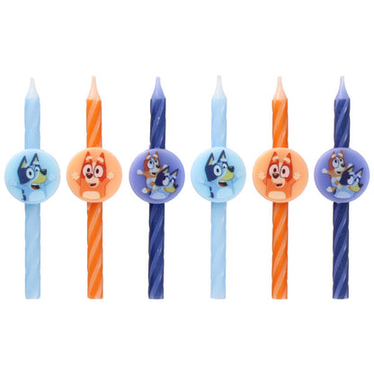 Six Bluey birthday candles in light blue, orange, and dark blue with swirl stripes and round character medallions, displayed in a row on a white background.