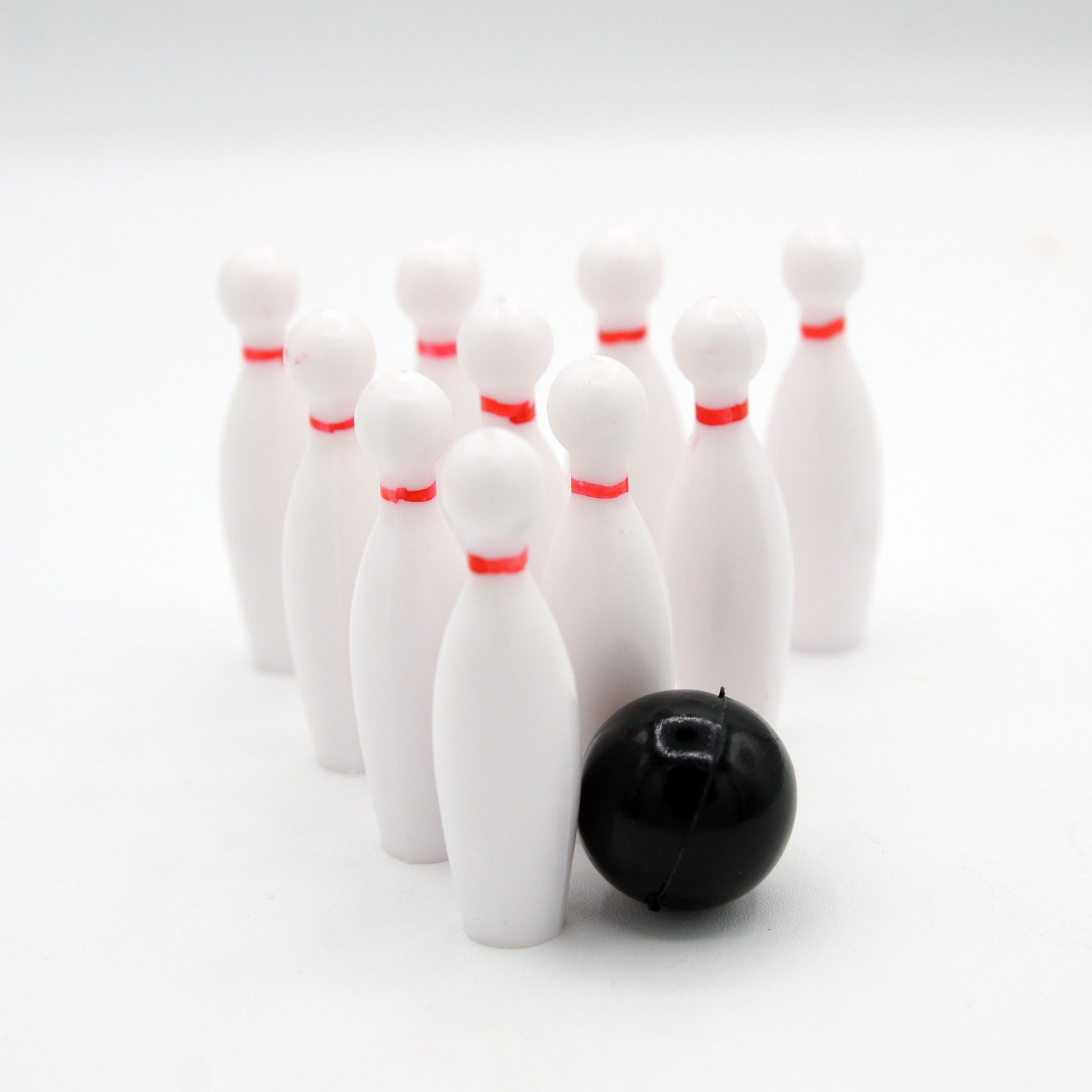 Bowling cake topper set including white pins with red stripes and a black bowling ball, perfect for bowling enthusiasts and celebratory events at bowling alleys.