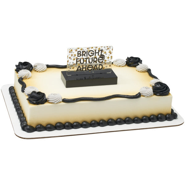 Rectangular sheet cake with smooth ivory frosting, black and white rosettes and piping, and a “BRIGHT FUTURE AHEAD” topper centered on top in a black base.