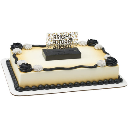 Rectangular sheet cake with smooth ivory frosting, black and white rosettes and piping, and a “BRIGHT FUTURE AHEAD” topper centered on top in a black base.