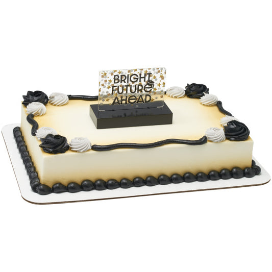 Rectangular sheet cake with smooth ivory frosting, black and white rosettes and piping, and a “BRIGHT FUTURE AHEAD” topper centered on top in a black base.