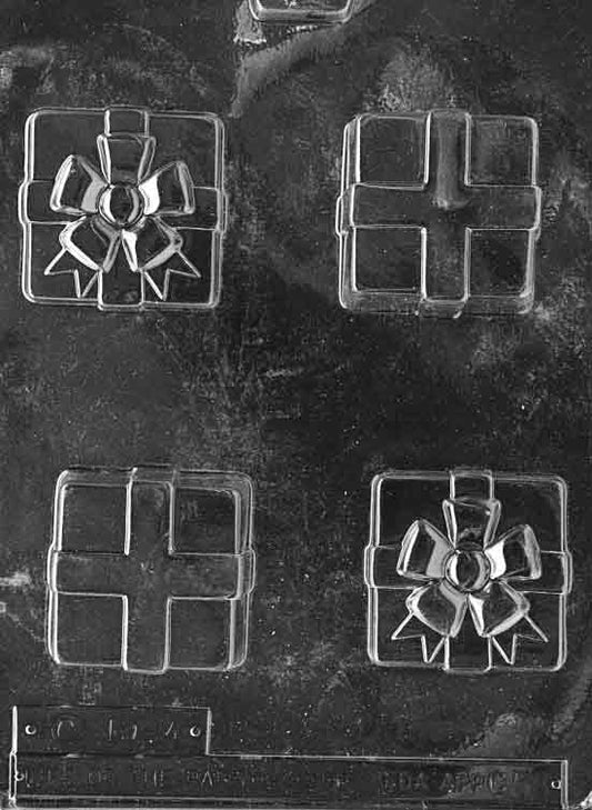 Clear mold of a small gift box with raised ribbon and bow; square footprint ~2 1/4 in, depth 1 1/8 in; C058