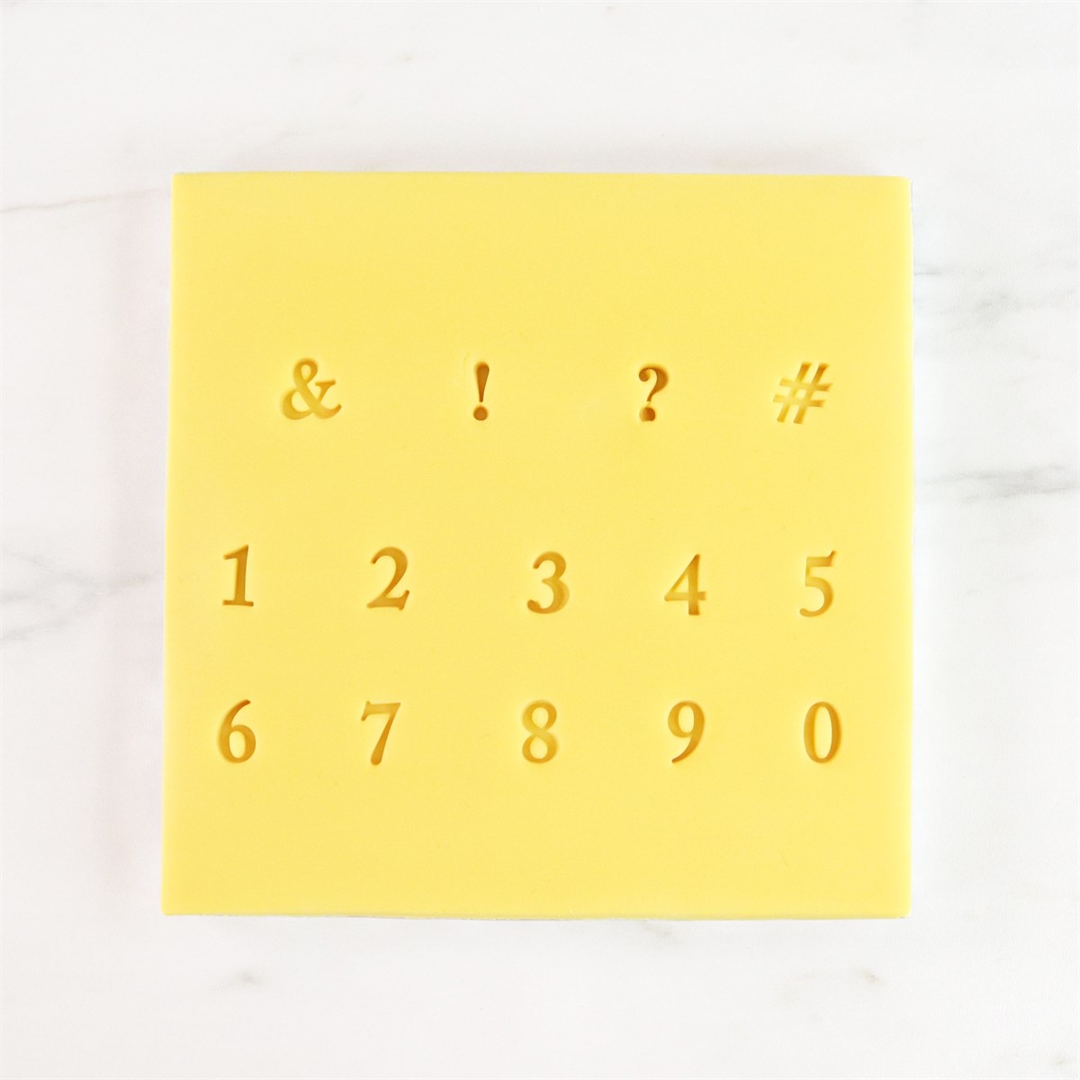 Close-up of yellow stamp sheet with numerals and punctuation from PME Fun Fonts Collection 2.