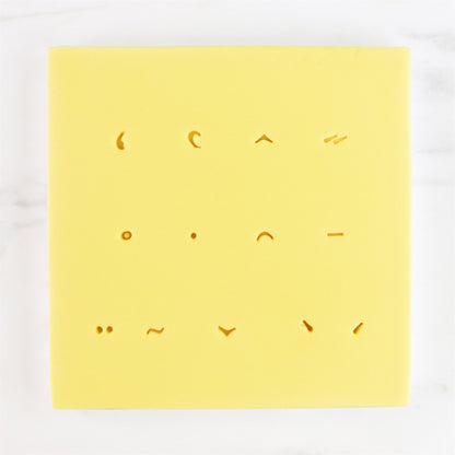 Close-up of yellow stamp sheet with accent marks for multilingual cake decorating using PME Fun Fonts Collection 2.