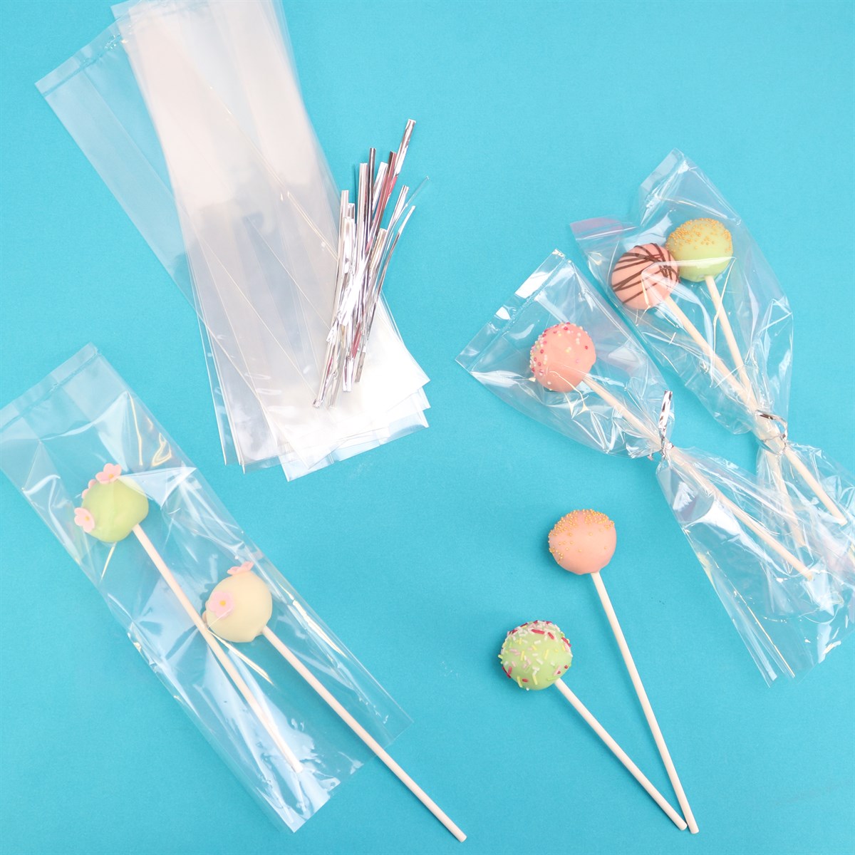 Clear PME cake pop bags with silver ties shown holding decorated cake pops on a blue background.