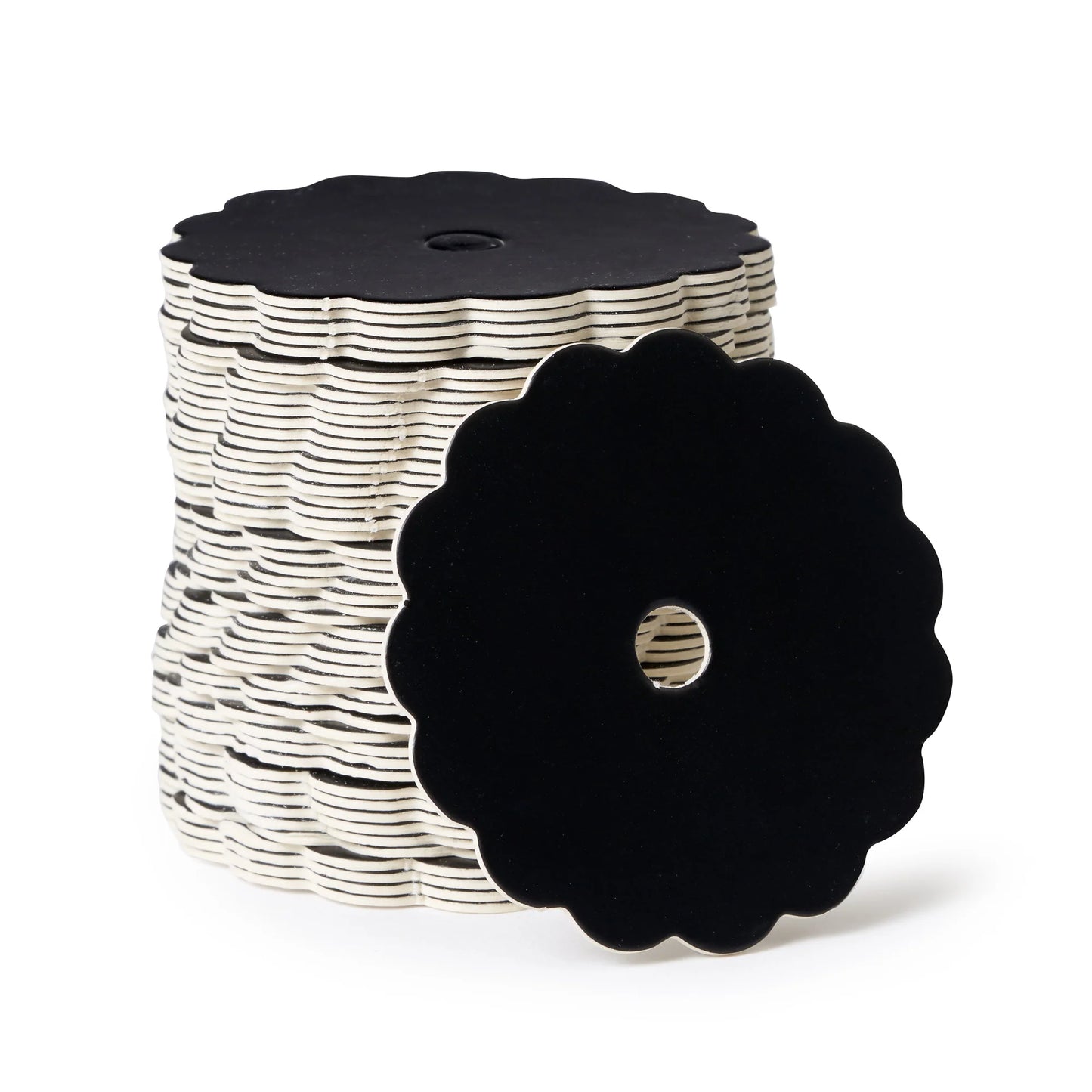 Stack of scalloped-edge black matte cake pop boards with center holes, shown with one board facing forward to display the floral-style edge.