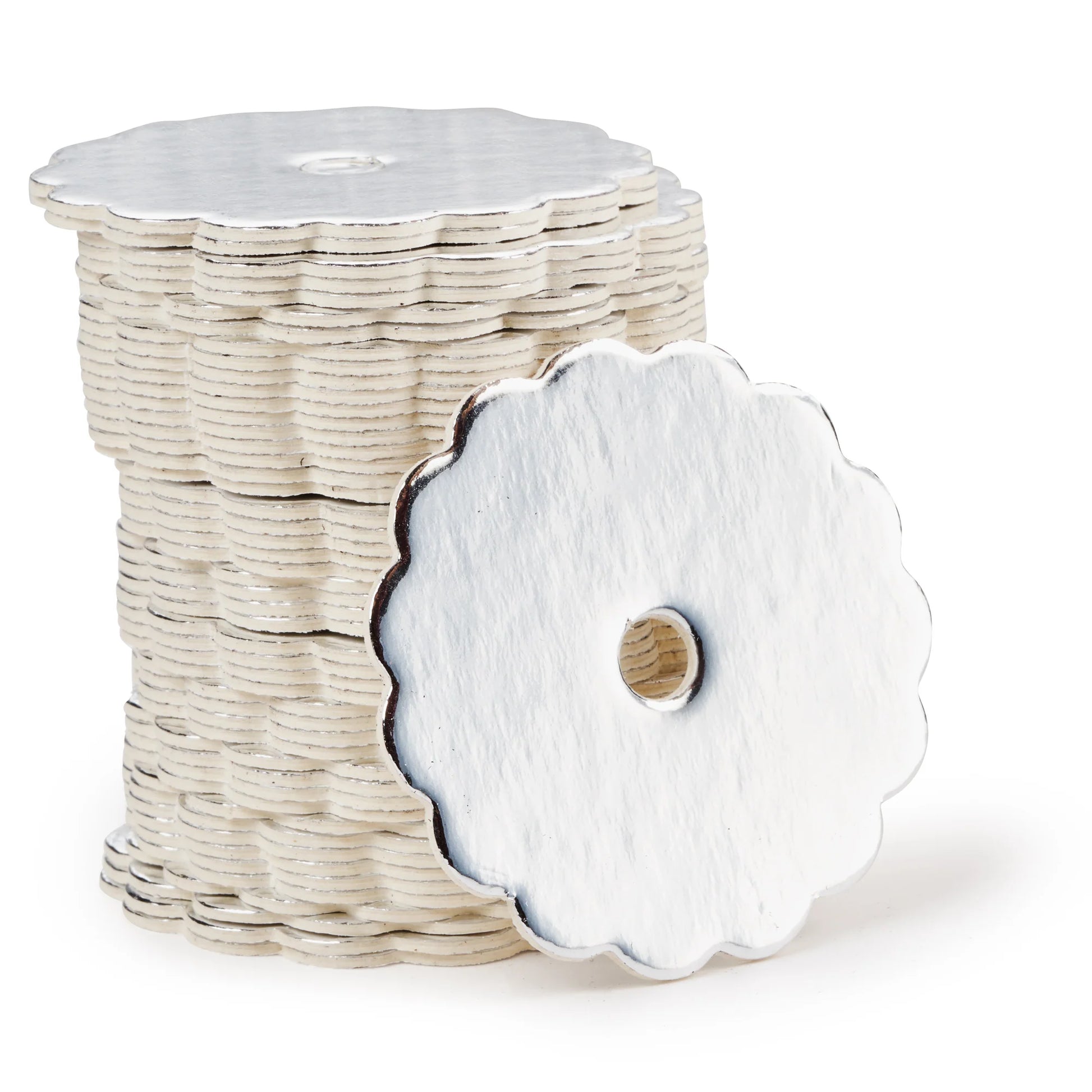 Stack of silver scalloped-edge cake pop boards with a shiny finish, each with a center hole, shown with one board propped forward to display detail.